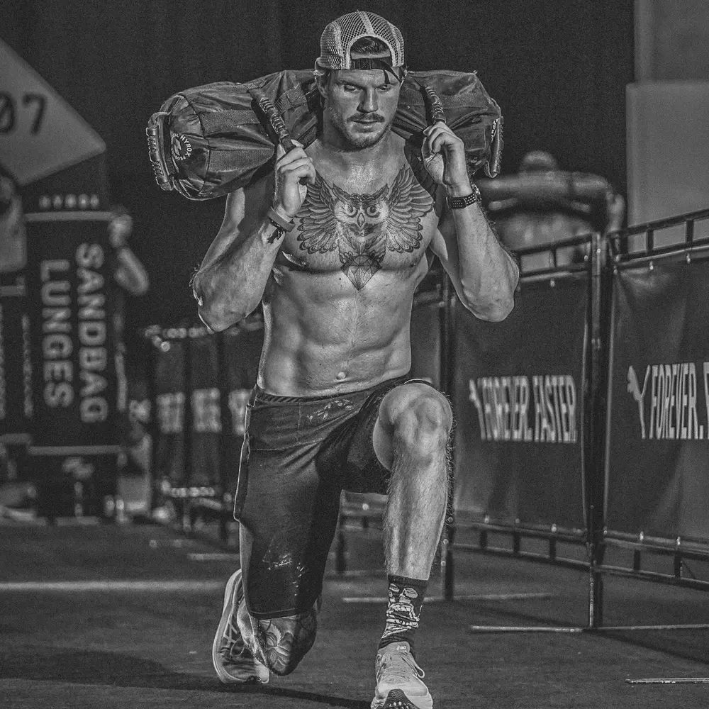A HYROX athlete doing sandbag lunges.
